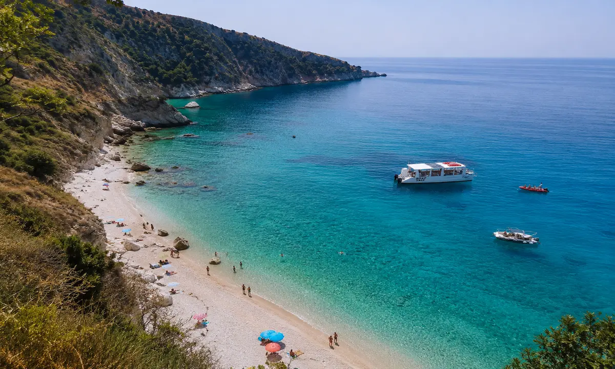 Filikuri Beach in Himare with crystal clear turquoise water and boats on the Albanian Riviera