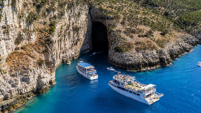 Tourist boats near Haxhi Ali Cave during a boat trip in Karaburun, Vlore Albania