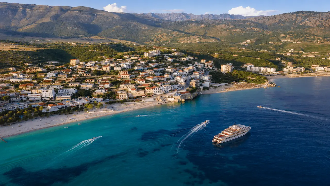 Aerial view of Himare coastline with boat tours and speedboats on the Albanian Riviera